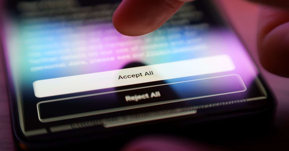 A person with a phone and their finger is hovering above a contract on the screen that says Accept All and Reject All.